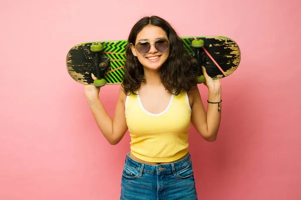 一个快乐的少女戴着复古复古太阳镜 准备用滑板滑旱冰的画像 — 图库照片
