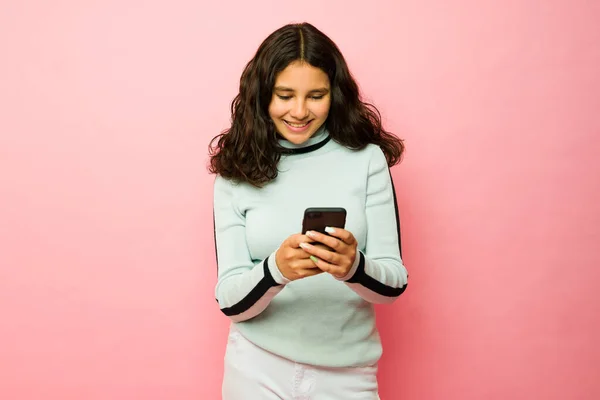 兴奋的少女惊慌失措地在智能手机上发短信 在粉红工作室的背景下使用社交媒体 — 图库照片