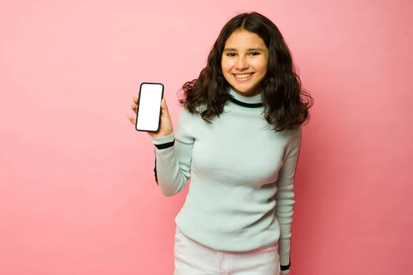 快乐的拉丁少女在使用社交媒体和微笑时展示她的新智能手机屏幕和发短信 — 图库照片