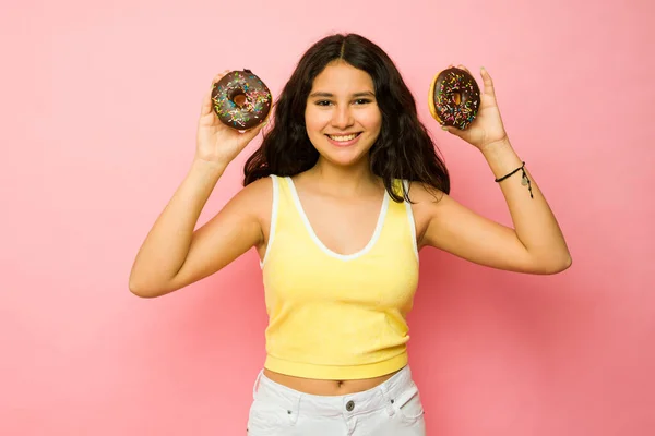 소녀가 초콜릿 도넛을 먹으면서 분홍색 옆에서 즐거운 시간을 보내고 — 스톡 사진