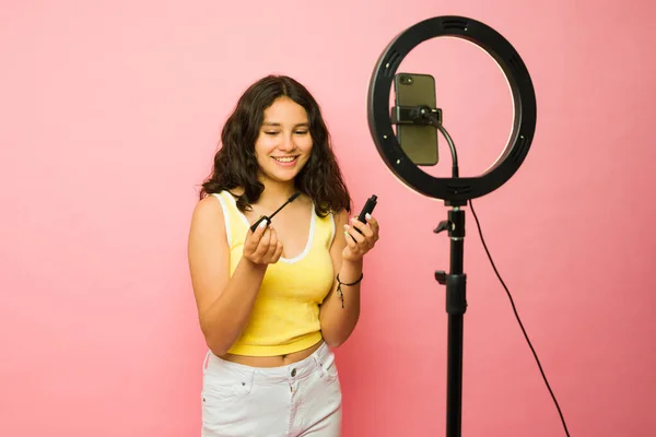 在用化妆品和化妆品为社交媒体拍摄视频时 快乐的13岁少女和有影响力的人面带微笑 — 图库照片