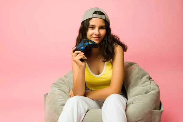 一个13岁女孩在放松在豆袋上进行眼神交流并准备玩电子游戏的工作室肖像 — 图库照片