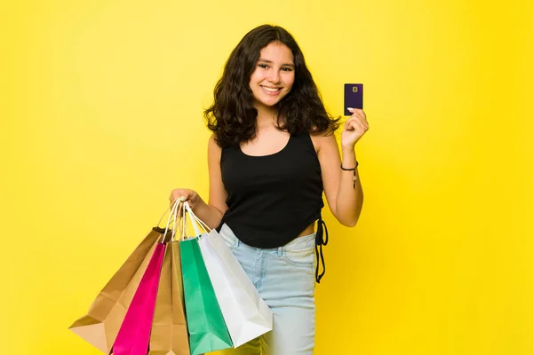 ヒスパニック系の13歳の女の子彼女のクレジットカードを示し ギフトの支払いながらショッピングモールで服を買う — ストック写真