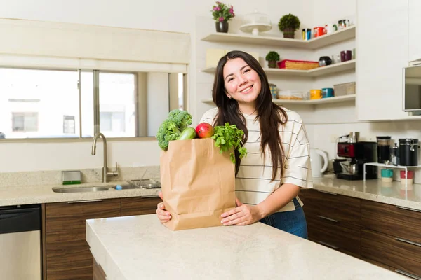 在厨房里过着素食生活的迷人而快乐的女人在去超市后准备用蔬菜烹调健康的食物 — 图库照片