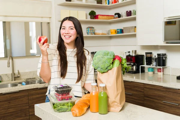 健康的な野菜や果物をキッチンで調理する準備ができている間に陽気に見えるビーガンライフスタイルを持つ興奮した美しい女性 — ストック写真