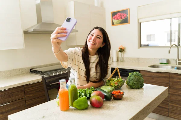 快乐的年轻女性 素食主义者的生活方式 一边在厨房里用智能手机自拍一边做健康的菜谱 — 图库照片