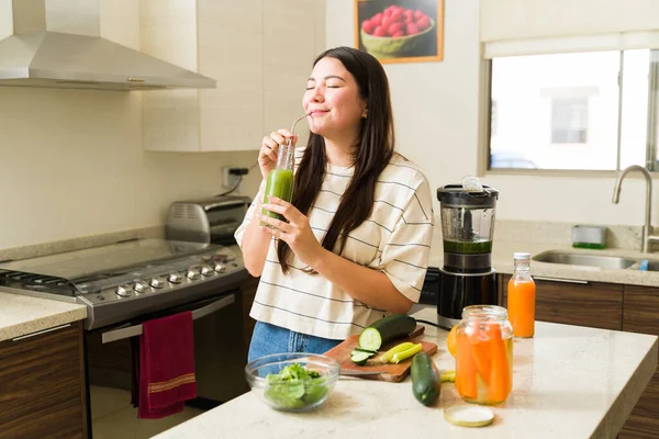 一个快乐的素食主义者女人在早上喝着美味的健康的绿色软糖 同时过着素食主义者的生活 — 图库照片