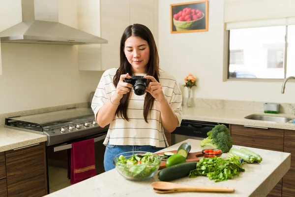 素食影响者女性在烹调素食菜谱之前 会在社交媒体上为自己的健康有机蔬菜和水果拍照 — 图库照片