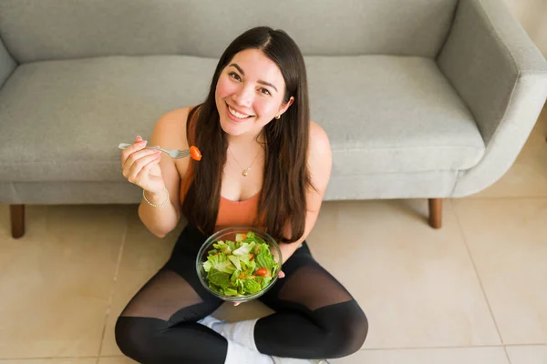 健康的健康女性 素食主义者的生活方式 吃着绿色沙拉 在家里锻炼后面带微笑 — 图库照片