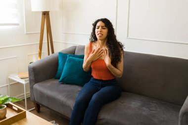 Stresli, taşikardiden muzdarip, göğüs ağrısı çeken ya da anksiyete krizi geçiren genç bir kadın.