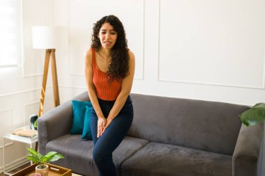 Endişeli İspanyol genç kadın tuvalete gitmek istiyor ve idrar tutamama sorunu var.