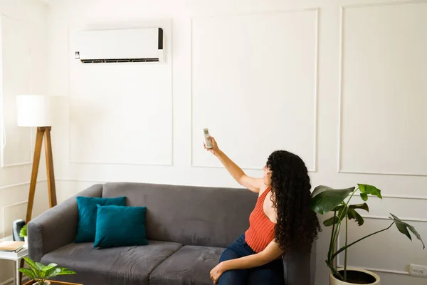 Lateinamerikanische Junge Frau Schaltet Die Klimaanlage Ihrem Wohnzimmer Ein Während — Stockfoto