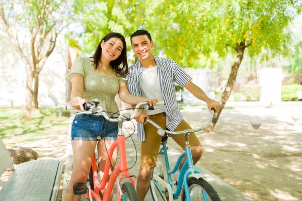 아름다운 부부가 데이트중에 공원에서 빈티지 자전거를 타면서 웃으며 카메라를 있습니다 — 스톡 사진