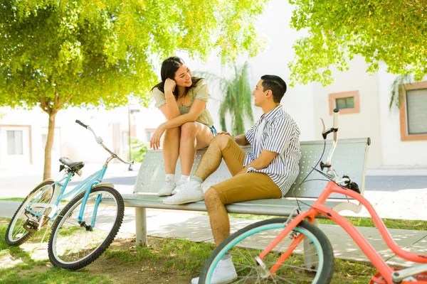 公園のベンチに座って ヴィンテージ自転車に乗って愛の気持ちを語りながらリラックスした魅力的なカップル — ストック写真