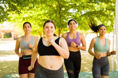 Büyük, iri yarı, gülümseyen, mutlu görünen, koşmaktan ve çeşitli kadınlarla dışarıda egzersiz yapmaktan hoşlanan bir kadın. 