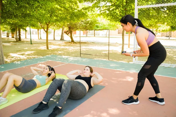 Fitness Coach Training Diverse Young Women Outdoors Doing Sit Ups — Stock Photo, Image