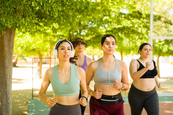 Mujeres Jóvenes Deportistas Activas Con Auriculares Corriendo Juntas Parque Haciendo —  Fotos de Stock