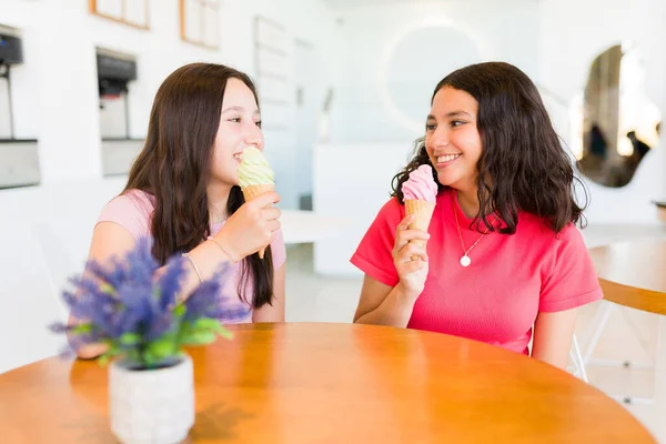 一緒に冷凍ヨーグルト店に行くと楽しいしながらアイスクリームコーンを食べながら話を楽しんで陽気な幸せなティーンの女の子 — ストック写真