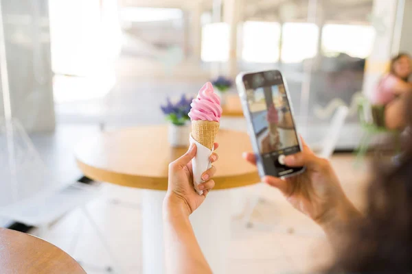 靠近一个年轻女子 她用智能手机从后面给她美味的草莓冰淇淋锥拍照 — 图库照片