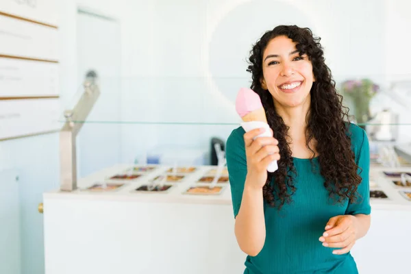 夏の間にアイスクリームコーンを食べながら笑って楽しんでいる興奮した若い女性の肖像画 — ストック写真
