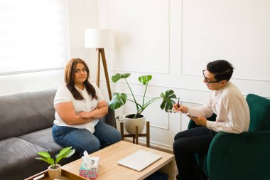 Terapi sırasında sorunları olan kızgın bir kadına akıl sağlığı tavsiyesi veren profesyonel bir psikolog.