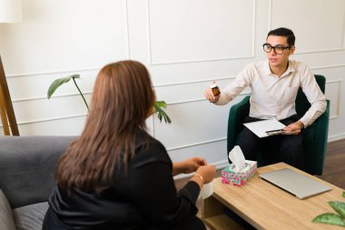 Erkek psikiyatrist yas tutan üzgün bir kadın için depresyon ve endişeyi tedavi etmek için antidepresan ilaç veriyor.