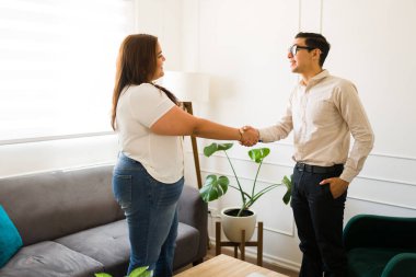 Kafkasyalı psikolog, ruh sağlığı sorunları nedeniyle terapi seansı sırasında mutlu kadın hastasıyla el sıkışıyor.