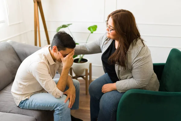 うつ病や精神衛生上の問題に苦しむ泣いている男を慰め治療中のプロの女性心理学者 — ストック写真