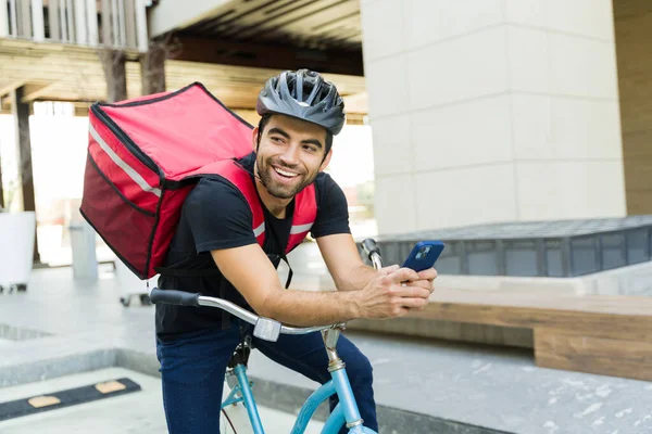 自転車に乗りながらバックパックを持って宅配サービスで働く陽気なラテン語の労働者の笑顔 — ストック写真