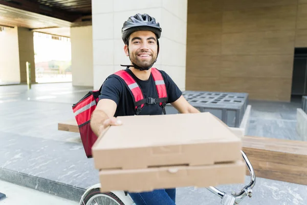 ハッピーラテン語の男はピザを提供し 自転車に乗って食品配達アプリのために働いていると笑顔 — ストック写真