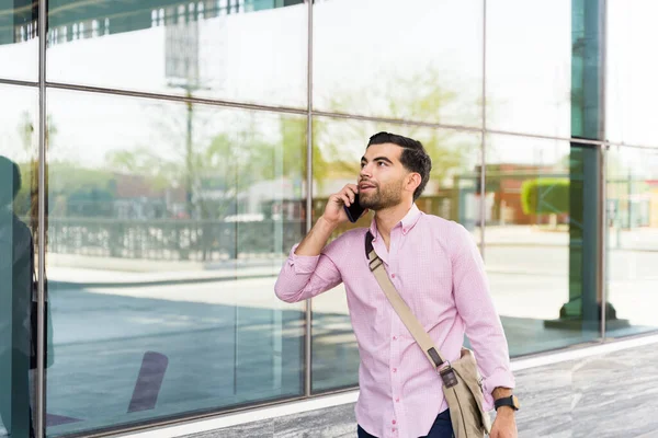 仕事の建物の外に出てオフィスに通勤している間に電話で話している普通のビジネスマン — ストック写真
