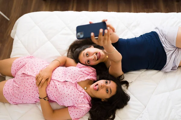 Neşeli Genç Kızlar Kankalar Pijamalarıyla Yatarken Sosyal Medya Için Cep — Stok fotoğraf
