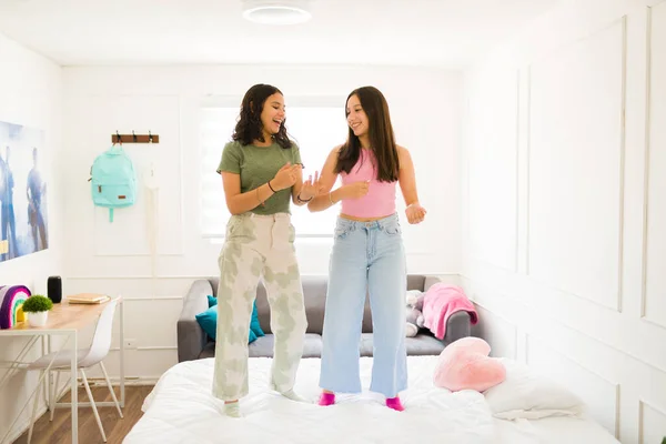 Uśmiechnięte Piękne Nastolatki Tańczące Łóżku Podczas Zabawy Słuchając Muzyki Sypialni — Zdjęcie stockowe