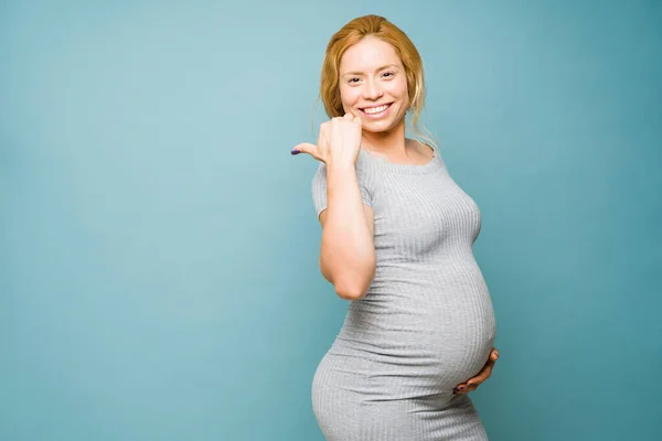 Όμορφη Έγκυος Γυναίκα Στα Της Δείχνει Χαρούμενη Και Δείχνει Προς — Φωτογραφία Αρχείου