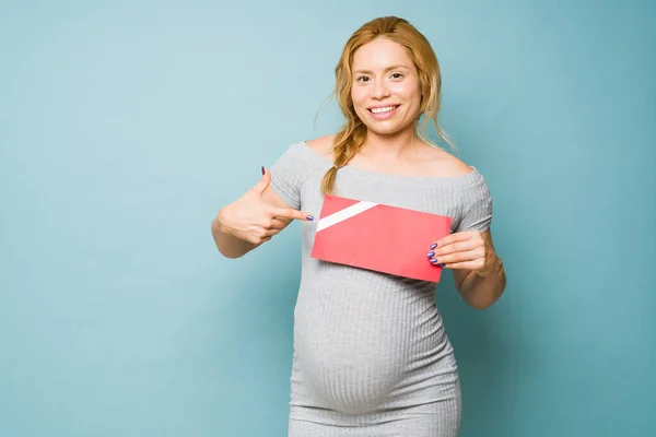 Portret Uroczej Kobiety Ciąży Trzydziestce Trzymającej Wskazującej Kartę Podarunkową Studiu — Zdjęcie stockowe