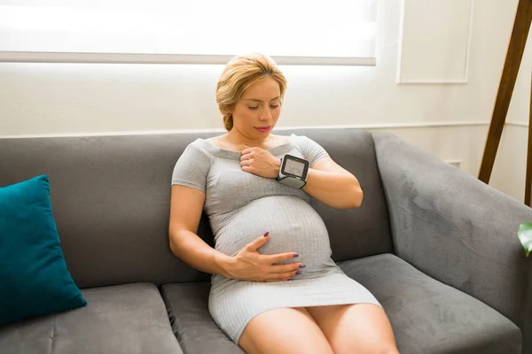 Koltuğunda Otururken Kalp Atış Hızı Monitörü Kullanan Hamile Bir Kadının — Stok fotoğraf
