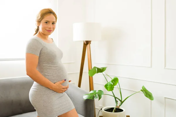 一个三十多岁的漂亮女人在客厅里享受怀孕的快乐而又悠闲的画像 — 图库照片