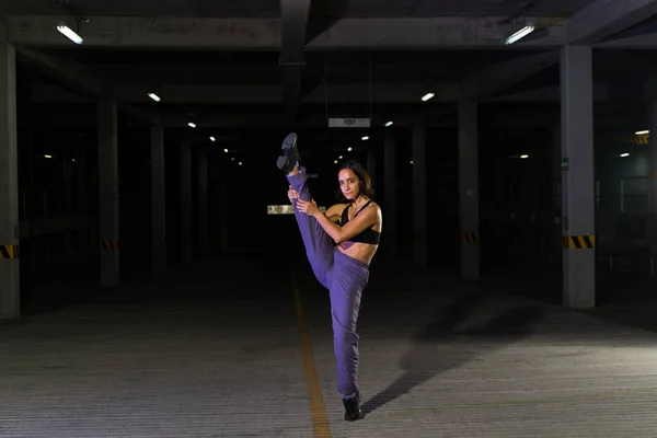 暗い駐車場で魅力的な都市の通りの女性ダンサーダンスとクールでファンキーに見えます — ストック写真