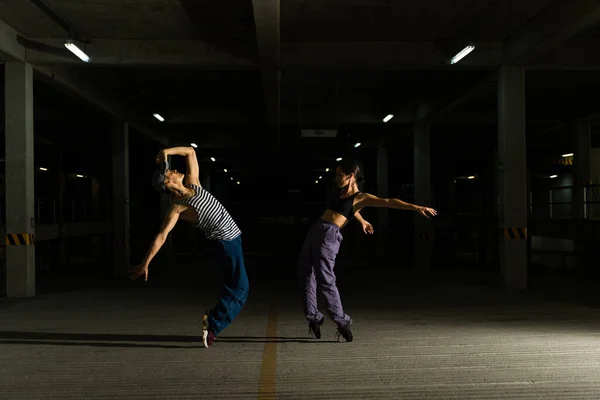 在黑暗的停车场里跳着很酷的自由式表演舞时 英俊的街头男舞者尽情地跳舞 — 图库照片