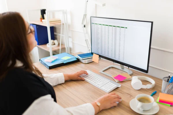 忙しいラテン語の専門家の女性は彼女のオフィスで管理作業をしながら 彼女のコンピュータ画面を見て — ストック写真
