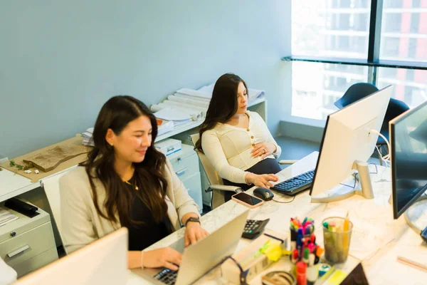 직장에서 동료와 책상에 컴퓨터로 일하는 임산부에 집중하 — 스톡 사진