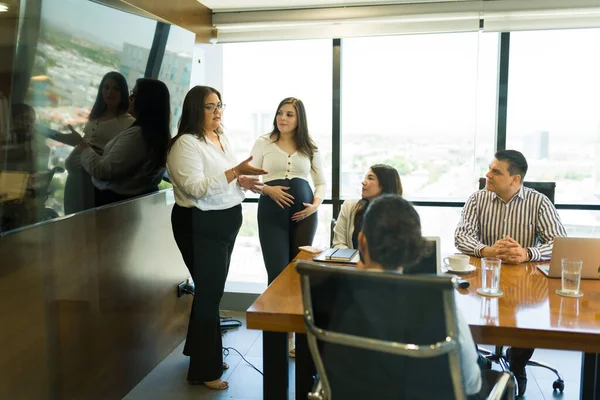 現代オフィスの会議室でチームにプレゼンテーションを与えるヒスパニックビジネス女性 — ストック写真