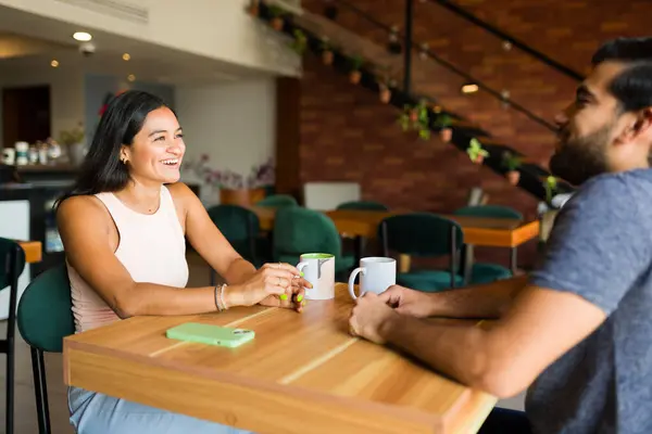 一緒にコーヒーショップに座っている間 美しいラテン女性は彼女の日付のボーイフレンドと話をしながら笑顔 — ストック写真