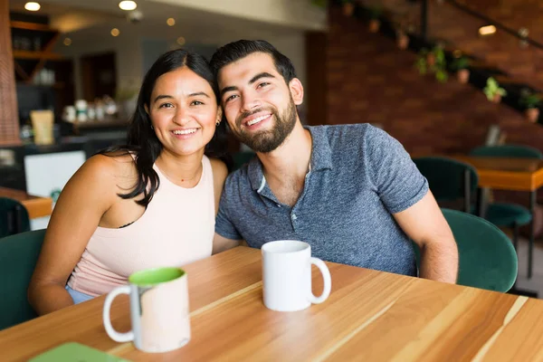 在一个美丽的咖啡馆喝咖啡时 一对快乐而美丽的情侣一边拥抱一边笑着 — 图库照片