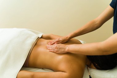 Terapist, sağlık güzellik merkezinde genç bir bayana masaj yapıyor. Rahatlatıcı bir tedavi için.