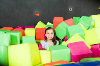 Köpük küplerle oynarken ve oyun alanında eğlenirken gülümseyen sevimli küçük kız.