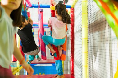 Oyun parkına tırmanan bir grup çocuğun boş zamanlarında arkadaşlarıyla eğlenceli bir oyun oynamaları.