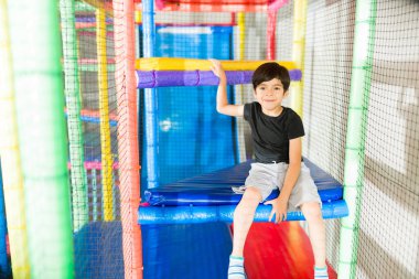 Kafkasyalı genç çocuk çocukluğunda arkadaşlarıyla oyun oynarken oyun odasında eğleniyor.