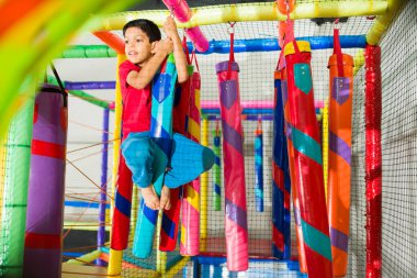 Aktif İspanyol çocuk arkadaşlarının oyun oynamasını beklerken şişme parkta çok eğleniyor.