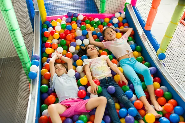 Eğlenceli çocuklar oyun sahasının top havuzunda oyun oynarken birlikte eğleniyorlar. 